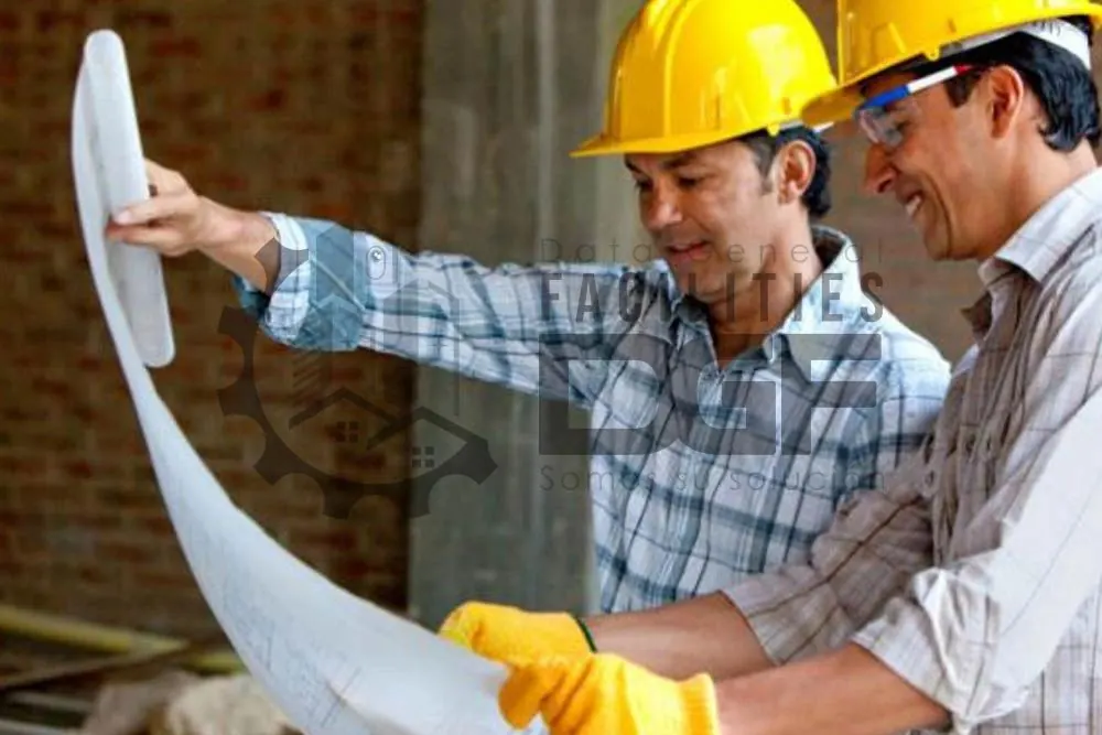Dos ingenieros con casco revisando planos de construcción