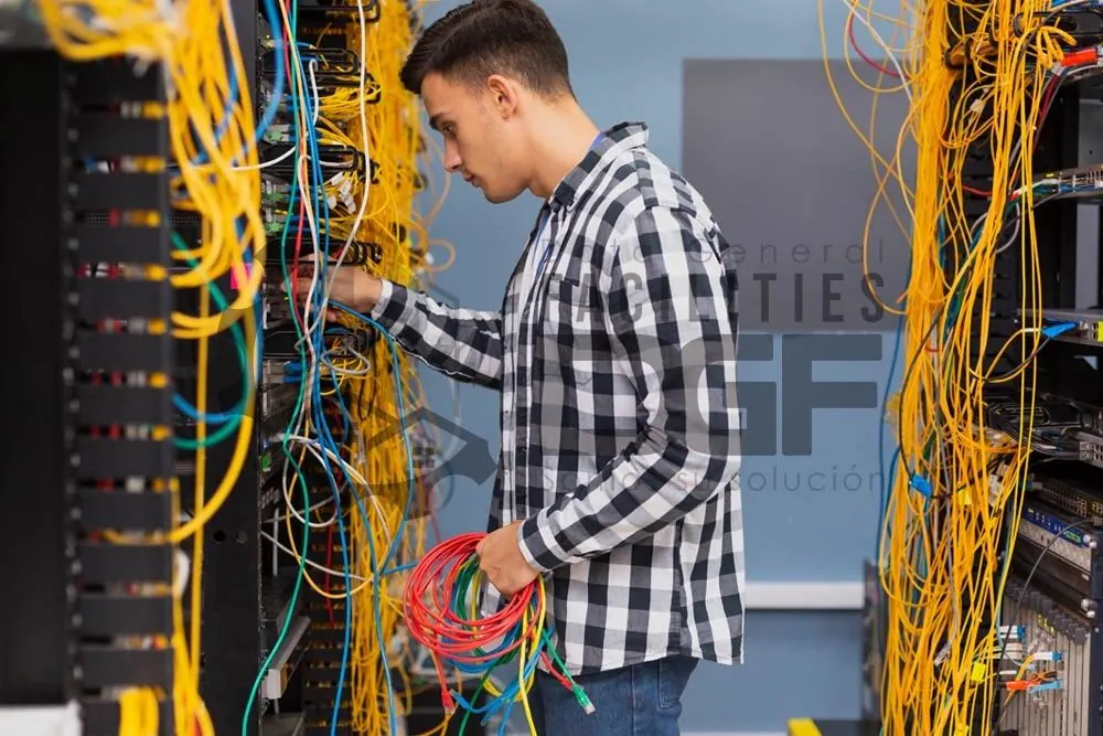 Técnico organizando el cableado de un rack de telecomunicaciones