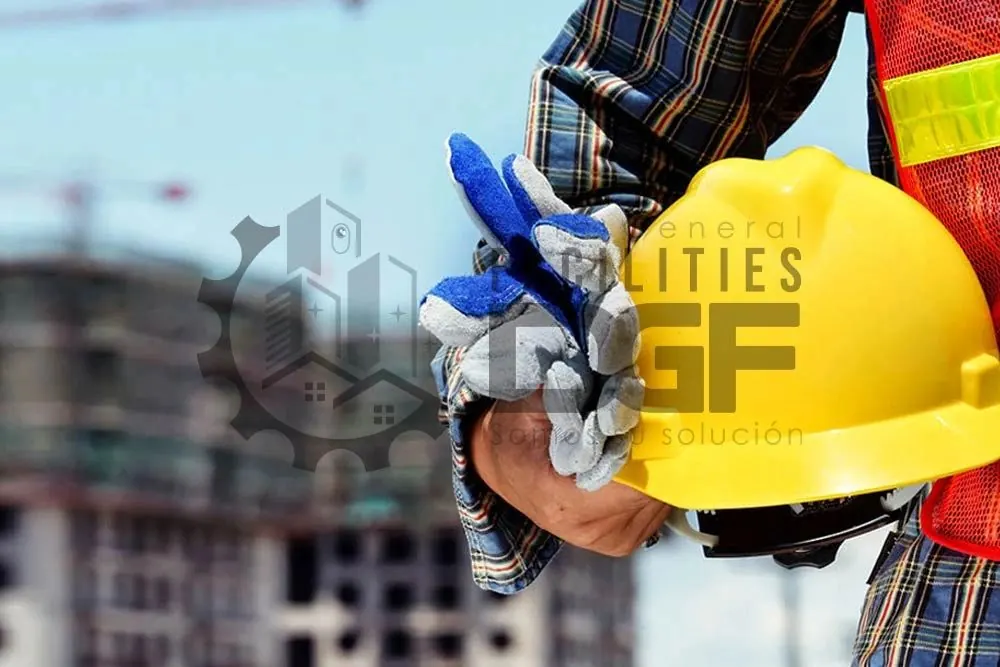 Trabajador de construcción con guantes sosteniendo un casco amarillo